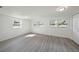 Bright bedroom featuring wood-look floors, white trim, and multiple windows allowing for natural light at 407 Cranberry Ln, Brandon, FL 33510