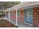 Inviting front porch featuring a brick facade, stylish light fixture, and a blue front door at 407 Cranberry Ln, Brandon, FL 33510