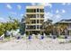 Multi-story building featuring lounge seating, beach access and tropical landscaping at 74 Gulf Blvd # 1B, Indian Rocks Beach, FL 33785