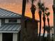Exterior of home features palm trees and a view of ocean during sunset at 74 Gulf Blvd # 1B, Indian Rocks Beach, FL 33785
