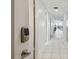 Bright hallway with white tile flooring and a secure Yale lock on the front door at 74 Gulf Blvd # 1B, Indian Rocks Beach, FL 33785