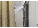 Laundry closet featuring stacked washer and dryer with neutral curtain at 74 Gulf Blvd # 1B, Indian Rocks Beach, FL 33785