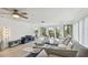 Bright living room with fan, balcony access, and neutral furnishings at 74 Gulf Blvd # 1B, Indian Rocks Beach, FL 33785