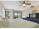 Cozy main bedroom with a ceiling fan, and a balcony overlooking greenery at 74 Gulf Blvd # 1B, Indian Rocks Beach, FL 33785