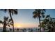 Charming patio area with comfortable seating, set against a backdrop of palm trees and calming ocean views at 74 Gulf Blvd # 1B, Indian Rocks Beach, FL 33785