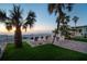 Outdoor patio view showcases well-maintained lawn with palm trees, beach, and Gulf views at 74 Gulf Blvd # 1B, Indian Rocks Beach, FL 33785