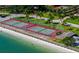 Picturesque aerial scene of tennis and shuffleboard courts along a pristine white sand beach at 7600 Bayshore Dr # 204, Treasure Island, FL 33706