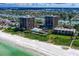 Beautiful aerial view of beachfront condominiums, the complex pool, and lush landscaping at 7600 Bayshore Dr # 204, Treasure Island, FL 33706