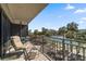 Balcony featuring cozy seating with view of tennis courts and lush tropical landscaping at 7600 Bayshore Dr # 204, Treasure Island, FL 33706