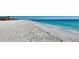 Expansive view of a beautiful white sand beach meeting the clear turquoise ocean water at 7600 Bayshore Dr # 204, Treasure Island, FL 33706