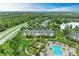Beautiful aerial view of the townhomes, pool, and surrounding lush green landscaping and serene lakes in this community at 8926 Manor Loop # 207, Lakewood Ranch, FL 34202