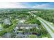 Extensive aerial view featuring townhomes with a community pool, parking, lush greenery and a road nearby at 8926 Manor Loop # 207, Lakewood Ranch, FL 34202