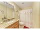 Well-lit bathroom featuring a marble-top vanity, toilet, and shower with a decorative shower curtain for added style at 8926 Manor Loop # 207, Lakewood Ranch, FL 34202