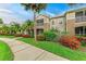 Attractive townhome exteriors with well-kept sidewalks, landscaping, tropical palm trees and green lawns at 8926 Manor Loop # 207, Lakewood Ranch, FL 34202