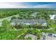 Scenic view of the townhome exteriors, surrounded by lush landscaping, green lawns, and palm trees around the pool at 8926 Manor Loop # 207, Lakewood Ranch, FL 34202