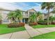 Charming townhome exterior featuring well-manicured landscaping, lush green lawn, and vibrant red flowers at 8926 Manor Loop # 207, Lakewood Ranch, FL 34202