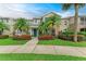 Charming townhome exterior featuring well-manicured landscaping, lush green lawn, and vibrant red flowers at 8926 Manor Loop # 207, Lakewood Ranch, FL 34202