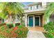 Inviting condo front entrance with lush landscaping and bright, teal colored doors at 8926 Manor Loop # 207, Lakewood Ranch, FL 34202