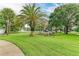 Serene green space features lush grass, mature trees, and picnic area for outdoor enjoyment at 8926 Manor Loop # 207, Lakewood Ranch, FL 34202