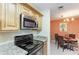 Updated kitchen features stainless steel appliances and granite countertops, seamlessly connected to the dining area at 8926 Manor Loop # 207, Lakewood Ranch, FL 34202