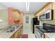 Modern kitchen with stainless steel appliances and a double sink at 8926 Manor Loop # 207, Lakewood Ranch, FL 34202