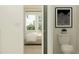 A bathroom is partially visible with a toilet and an abstract art piece, seen from an adjacent bedroom at 9705 Runaway Breeze Dr, Land O Lakes, FL 34637