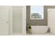 A modern bathroom features a freestanding tub, large window with natural light, and a separate shower area at 9705 Runaway Breeze Dr, Land O Lakes, FL 34637