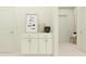 Bright hallway featuring a built-in cabinet with marble countertop, modern artwork, and neutral decor at 9705 Runaway Breeze Dr, Land O Lakes, FL 34637