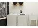 A well-lit laundry room features a washing machine, dryer, utility sink, and decorative baskets on a shelf at 9705 Runaway Breeze Dr, Land O Lakes, FL 34637