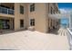 Expansive tiled balcony with ocean views, lounge chairs, and an exterior door for easy access at 10 Papaya St # 1404, Clearwater Beach, FL 33767