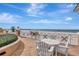 Balcony seating overlooking the beach with a white table, chairs, and decorative railing at 10 Papaya St # 1404, Clearwater Beach, FL 33767