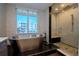 Luxurious bathroom featuring a freestanding tub, glass-enclosed shower, mosaic tile, and expansive windows at 10 Papaya St # 1404, Clearwater Beach, FL 33767