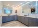 Sleek bathroom with dual sinks, modern fixtures, framed mirrors and ample counter space atop stylish blue-grey cabinetry at 10 Papaya St # 1404, Clearwater Beach, FL 33767