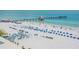 Expansive beach view with a pier, crowds of people, blue tents and chairs on a sunny day at 10 Papaya St # 1404, Clearwater Beach, FL 33767