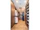 Large walk-in closet featuring wood-look floors, custom cabinets, drawers and multiple hanging areas for optimal organization at 10 Papaya St # 1404, Clearwater Beach, FL 33767