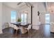 Bright dining room with modern chandelier, grey wood floors, and a large dark wood table at 10 Papaya St # 1404, Clearwater Beach, FL 33767