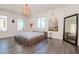 Bright main bedroom featuring large windows, grey wood floors, and platform bed at 10 Papaya St # 1404, Clearwater Beach, FL 33767