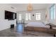 Main bedroom featuring large windows for natural light, modern chandelier, and platform bed at 10 Papaya St # 1404, Clearwater Beach, FL 33767