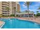 Beautiful outdoor pool surrounded by lounge chairs and tropical palms at resort condo complex at 10 Papaya St # 1404, Clearwater Beach, FL 33767