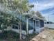 View of a sunroom featuring an open entrance and walls of windows showcasing lush outdoor scenery at 10127 Barnett Loop, Port Richey, FL 34668