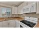 Bright kitchen featuring white cabinetry, tile backsplash, and stainless steel appliances at 10540 77Th Ter # 209, Seminole, FL 33772