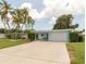 Inviting light blue house with a spacious driveway and mature palm trees at 10828 99Th Pl, Seminole, FL 33772