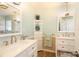 Bright bathroom featuring dual sinks, white cabinetry, and nautical-themed decor at 112 Forest Cir, Safety Harbor, FL 34695