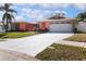 Well-kept single-story home with a spacious driveway, attached two-car garage, and stone accents at 112 Forest Cir, Safety Harbor, FL 34695