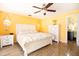 Yellow themed main bedroom with ensuite bathroom, tile floors, and ceiling fan at 112 Forest Cir, Safety Harbor, FL 34695