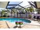 Sparkling pool surrounded by brick pavers and tropical landscaping in a screened enclosure at 112 Forest Cir, Safety Harbor, FL 34695