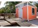 Stylish shed with a roll-up door and a wooden deck, offering ample storage space and convenience at 112 Forest Cir, Safety Harbor, FL 34695