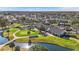 Aerial view of the community golf course and clubhouse, highlighting the manicured green, water feature and cart parking at 11308 Pocket Brook Dr, Tampa, FL 33635