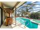 Screened in pool area with a tiki bar and jacuzzi at 11308 Pocket Brook Dr, Tampa, FL 33635