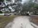 Single-story home nestled among mature trees, featuring a large lot and ample parking space at 12205 Greenland Dr, Riverview, FL 33579